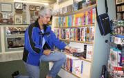 Joanne Drane, volunteer, stocks the shelves with videos and DVDs at the Auxiliary of Shore Memorial’s Egg Harbor Township Thrift Shop.